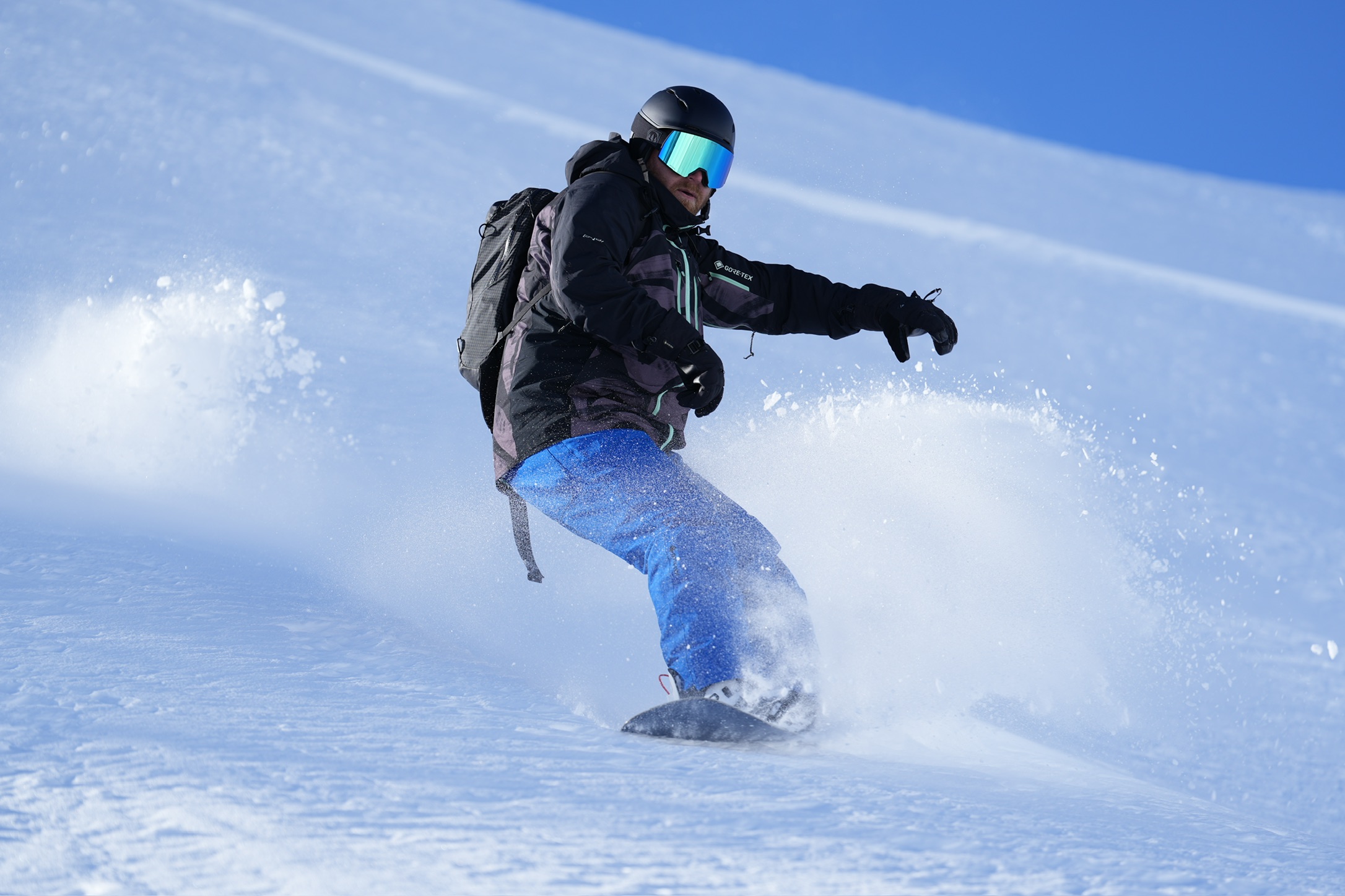 Snowboarder carving through powder